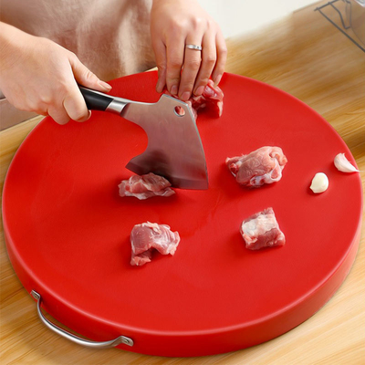 La cucina della famiglia che cucina gli strumenti ispessisce il PE di plastica intorno al blocchetto di spezzettamento tagliato